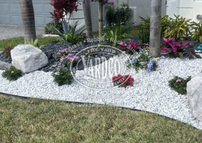 White Pebble garden bed with Rose Quartz Boulder - supplied by Yardco.