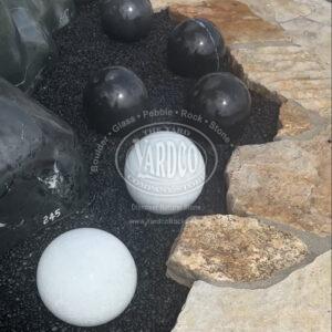 Polished black and white marble sphere with natural veining.